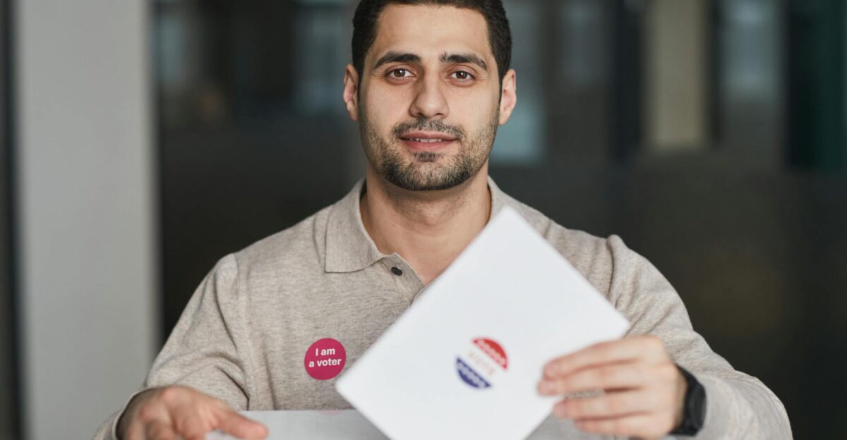 A man with a I am a voter sticker casting his ballot on election day