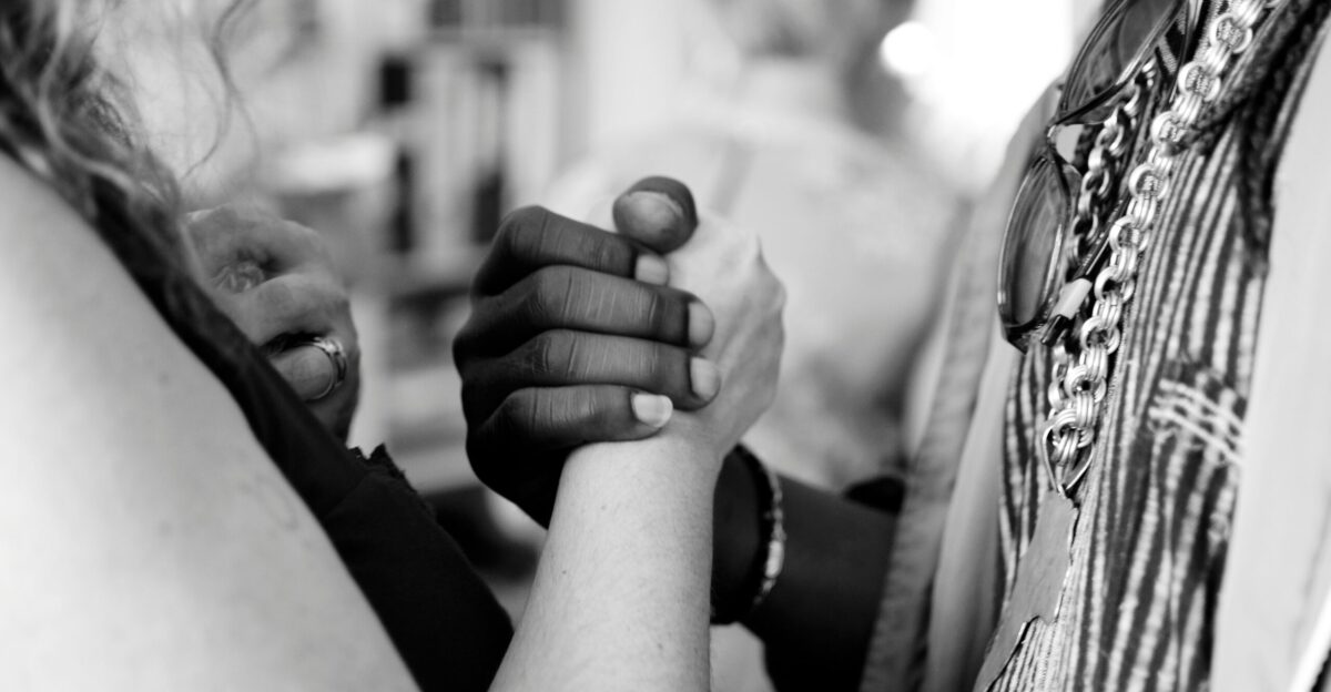 grayscale photo of man and woman holding their hands