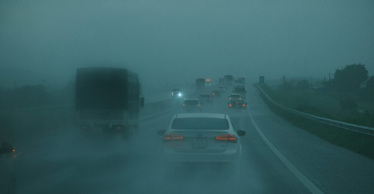 Cars driving on a wet highway in heavy fog